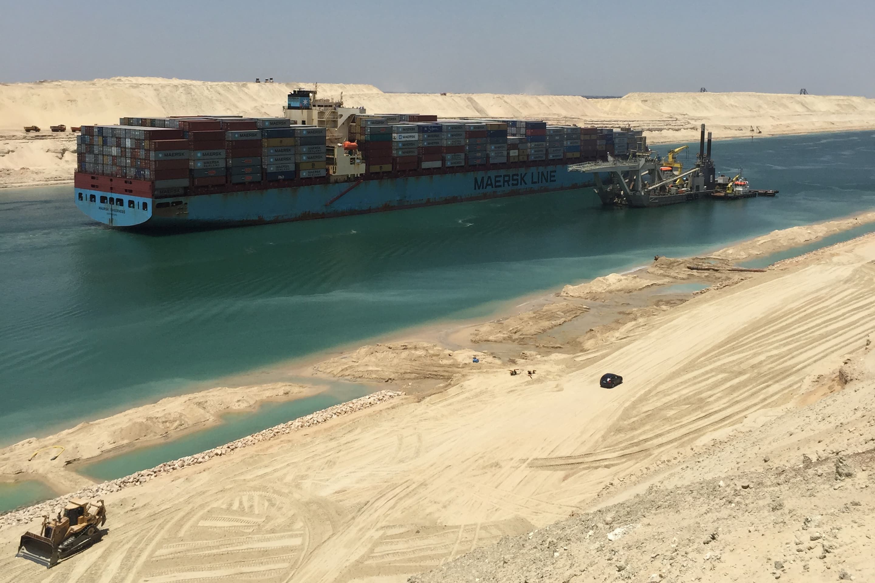 A container vessel passes the dredger Phoenix 1 during a trial run through the parallel canal