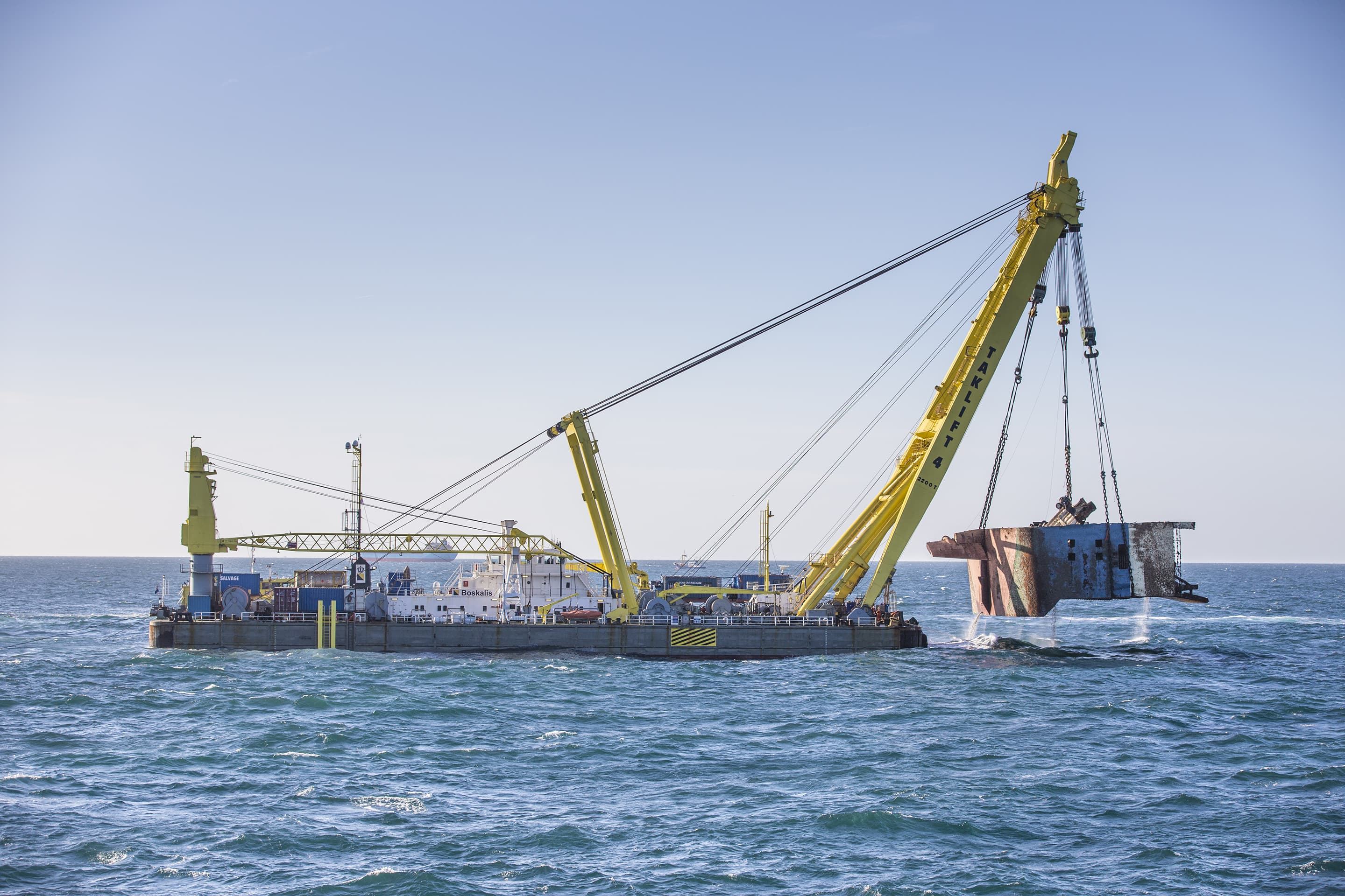 The floating sheerleg Taklift 4 is lifting one of the wreck sections