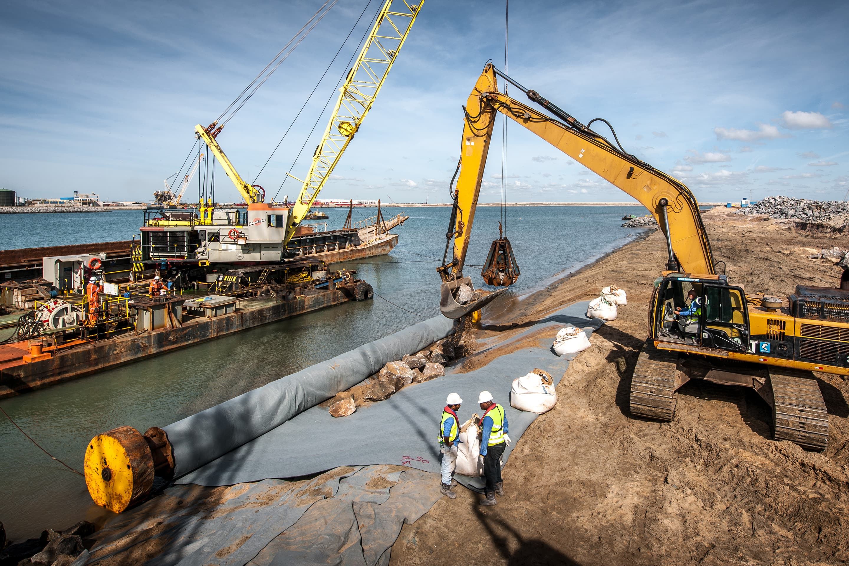 Installation of geotextile to protect a breakwater against erosion