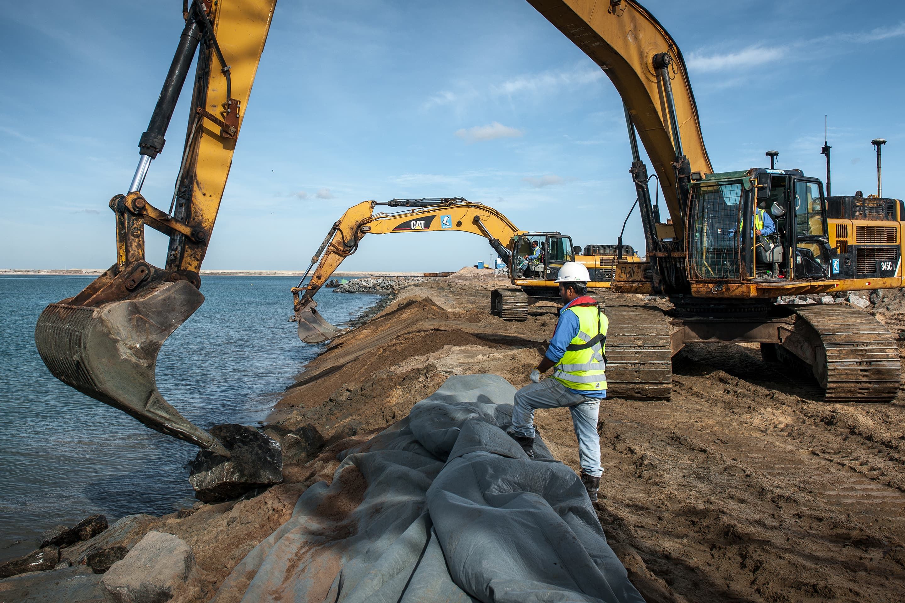 Installation of geotextile to protect a breakwater against erosion